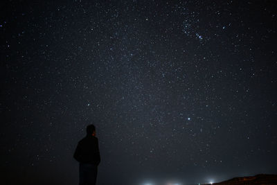 Low angle view of silhouette woman standing against star field