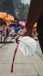 Midsection of man holding feather