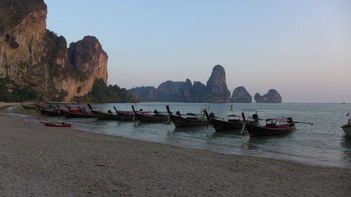 Boats moored on sea against clear sky