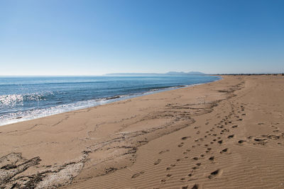 Scenic view of beach against clear blue sky