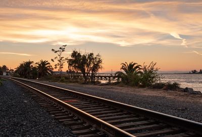Railroad tracks against sky during sunset