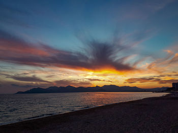 Scenic view of sea against dramatic sky during sunset