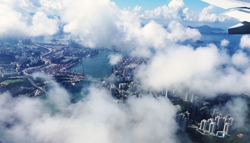 Aerial view of city against cloudy sky