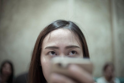 Close-up of young woman using mobile phone at restaurant