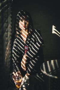 Portrait of woman holding disposable cup while sitting on seat