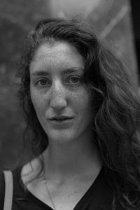 Close-up portrait of young woman standing against wall