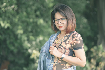 Portrait of woman standing against plants