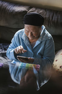 Smiling senior woman using smart phone at home