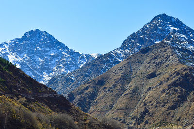 Scenic view of snowcapped mountains against clear blue sky