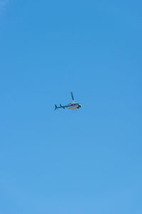 Low angle view of airplane against clear blue sky