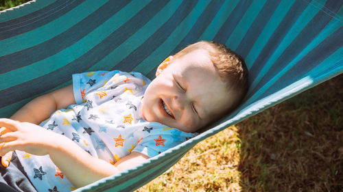 High angle view of boy lying on hammock