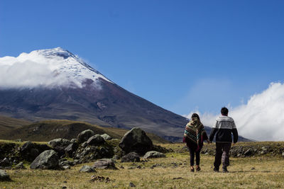 Rear view of people on snowcapped mountains against sky