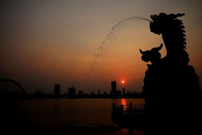 Silhouette of statue at sunset