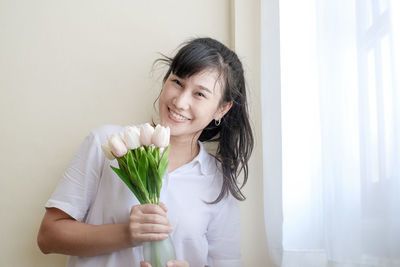 Portrait of smiling woman holding flower