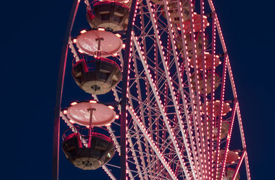 Low angle view of illuminated ferris wheel against sky at night