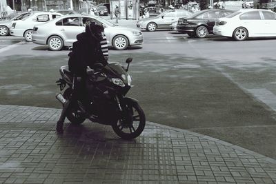 Woman riding motorcycle on street in city