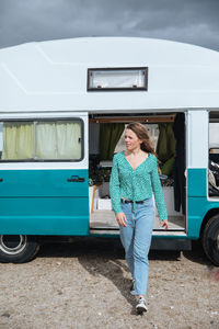 Woman walking against camper van