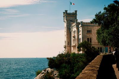 Building by sea against sky