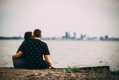 Rear view of couple looking at sea against sky