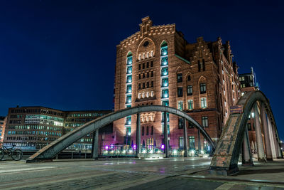 Low angle view of illuminated bridge against sky at night