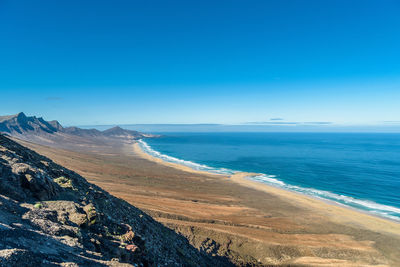 Scenic view of sea against clear blue sky