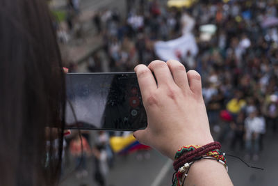 Close-up of woman photographing with mobile phone in city