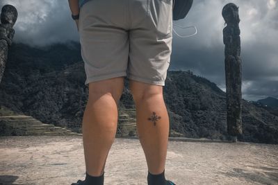 Low section of man standing on mountain