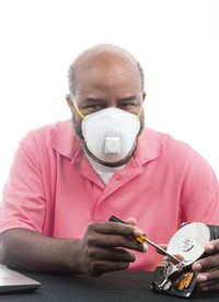 Portrait of man holding camera over white background