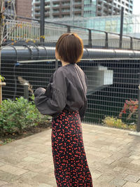 Rear view of woman standing on footpath