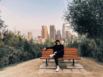 Man sitting on bench in city park