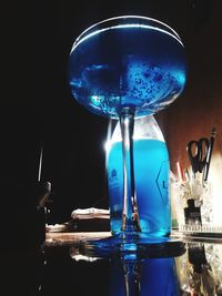 Close-up of wine glass on illuminated table