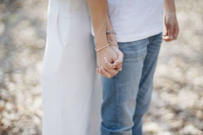 Low section of couple holding hands