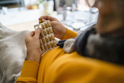 Man removing capsule from blister pack at home