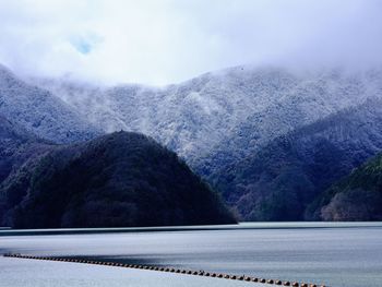 Road by mountains against sky