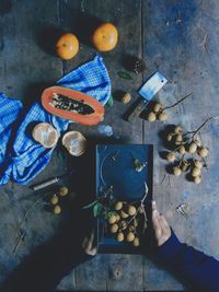 High angle view of hand holding fruits on table