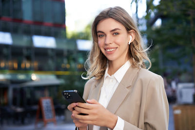 Portrait of young businesswoman using phone