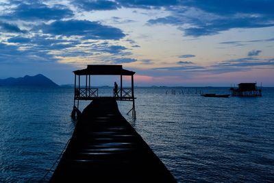 Pier over sea against sky during sunset