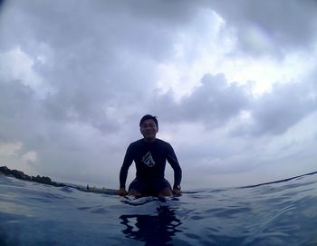 Full length of man swimming in sea against sky