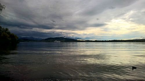 Scenic view of lake against cloudy sky