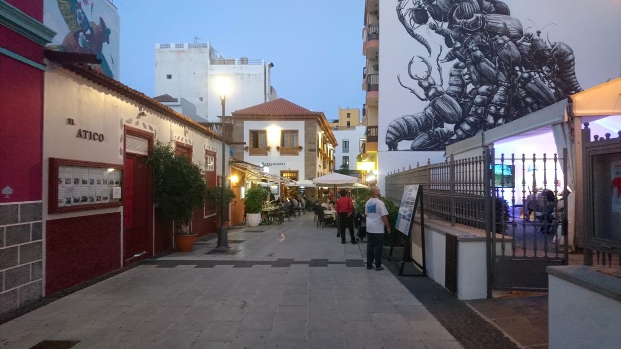 STREET AMIDST BUILDINGS AGAINST SKY IN CITY