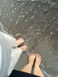 Low section of woman standing on sand