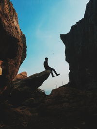 Silhouette man with arms outstretched against sky