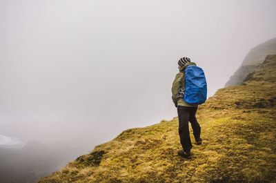 Rear view of a man walking on landscape