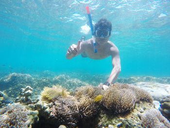 Full length of shirtless boy swimming in sea