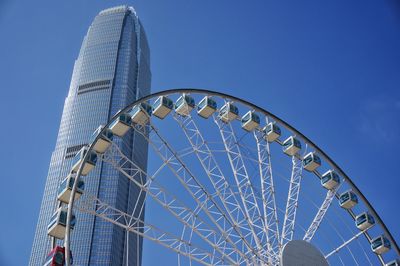 Low angle view of ferris wheel against blue sky