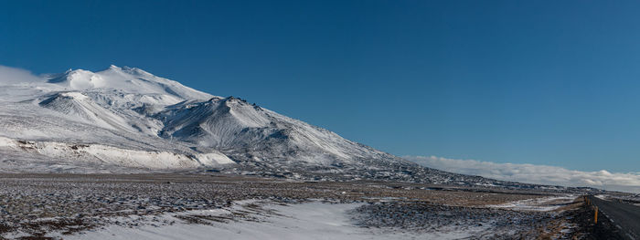 Panoramic view of snow covered volcanic mountain with road