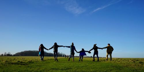 Group of people on field against sky