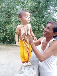 Full length of a happy girl holding baby outdoors