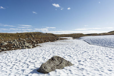 Surface level of snow on land against sky