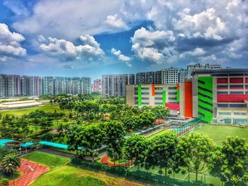 Trees and cityscape against sky